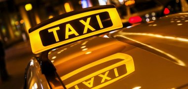 Taxischild mit Spiegelung im Dach des Taxis