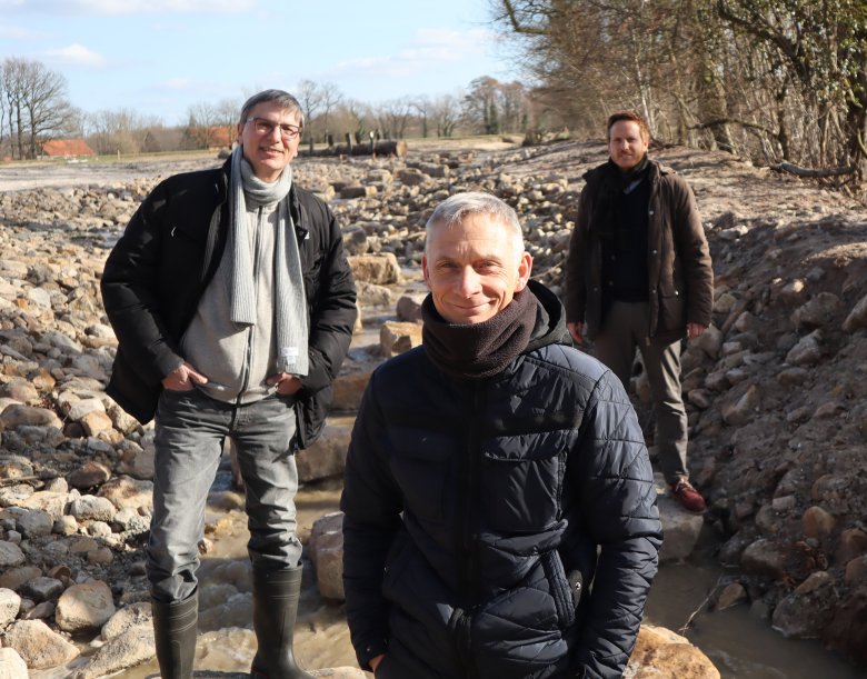 Nach viermonatiger Bauzeit freuen sich Stefan Sibilski (Sachgebietsleiter Kultur- und Wasserbau), Projektleiter Oliver Juhnke (Abteilung Tiefbau) und Henrik Egeler (Leiter der Abteilung Tiefbau) über den erfolgreichen Probedurchlauf im neuen Bachbett. Foto: Kreis Gütersloh