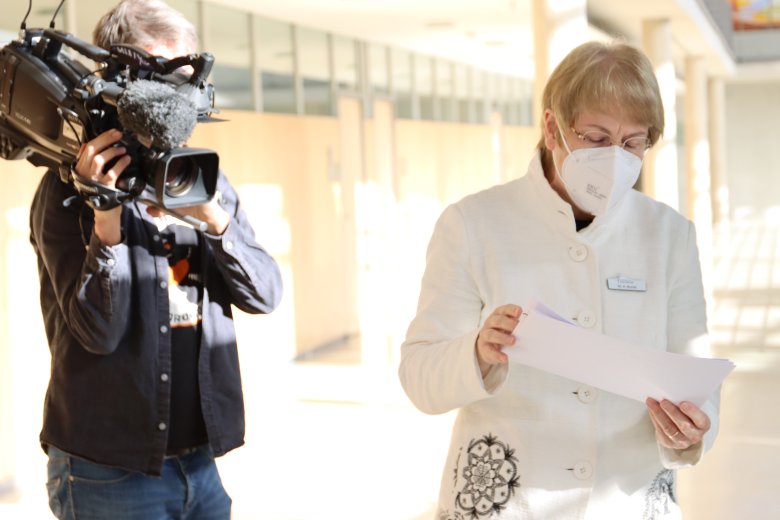 Dr. Anne Bunte, Leiterin Abteilung Gesundheit, hält Zettel in der Hand. Auf der linken Seite des Bildes steht ein Kameramann des Westdeutschen Rundfunks. 