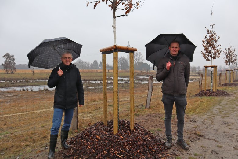 Eberhard Beckemeyer, Abteilung Umwelt des Kreises Gütersloh, und Christoph Schürmann-Averbeck, Firma Roehse & Fischer, bei der Abnahme der Eichenallee an der Glenne. Sie stehen neben einem neu gepflanzten Baum.