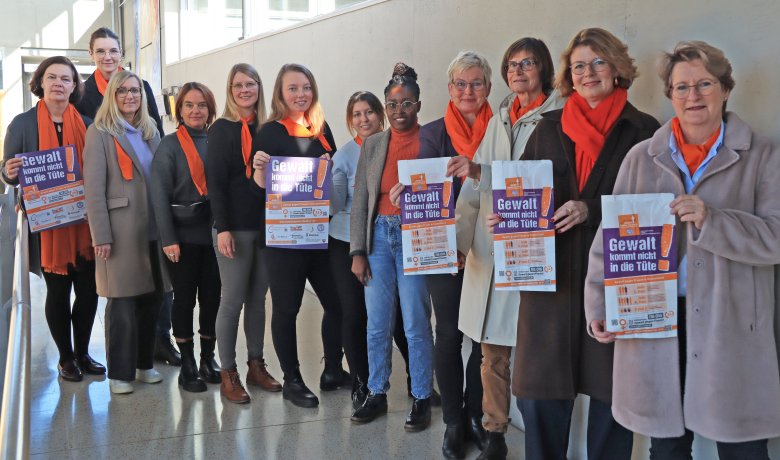 Frauen stehen nebeneinander, einige davon halten Brötchentüten oder Plakate in der Hand.