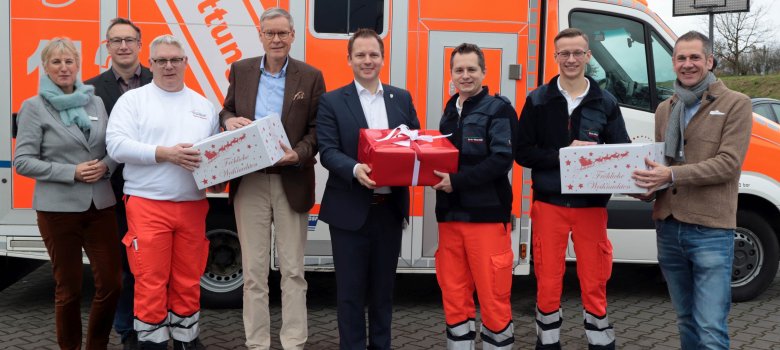 Verschiedene Pakete von Landrat Sven-Georg Adenauer und Bürgermeister Michael Meyer-Hermann nahmen die Mitarbeitenden der Rettungswache in Versmold entgegen (v.l.): Dr. Angela Lißner (Dezernentin Ordnung, Gesundheit und Bevölkerungsschutz), Sven Rabaschus (Stadt Versmold), Stefan Broer (Rettungswache Versmold), Landrat Sven-Georg Adenauer, Bürgermeister Michael Meyer-Hermann, Sven Ranocha (Leiter der Rettungswache Versmold), Jason Zierach (Rettungswache Versmold) und Jürgen Theis (Leiter der Abteilung Bevölkerungsschutz). 