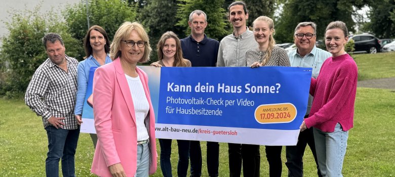 Die Projektteilnehmenden stehen auf einer Wiese und präsentieren das PV-Check-Plakat.