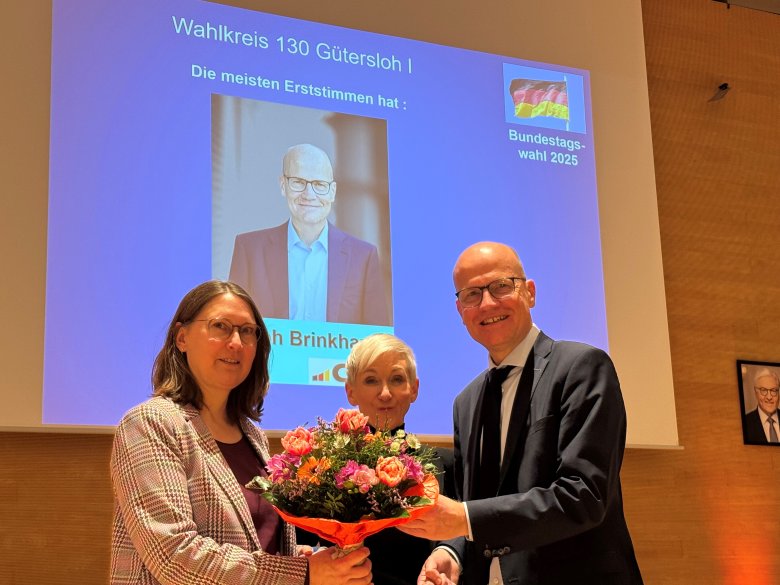 Ralph Brinkhaus erhält einen Blumenstrauß im Kreishaus Gütersloh