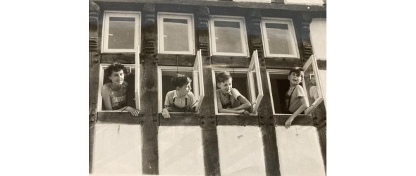 Ilse Strecker und ihre Söhne ca. 1950 in Melle. Sie schauen dabei aus geöffneten Fenstern.